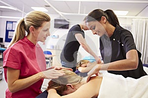 Teacher Helping Student Training To Become Masseuse