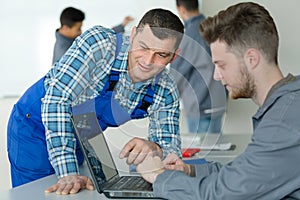 Teacher helping student using laptop