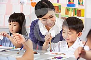 Teacher Helping Students During Art Class