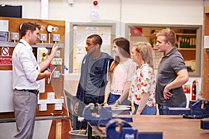 Teacher Helping Students Training To Be Electricians