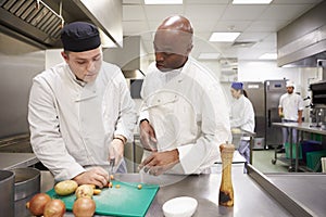 Teacher Helping Students Training To Work In Catering