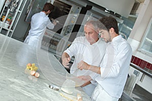 Teacher helping students training to work in catering