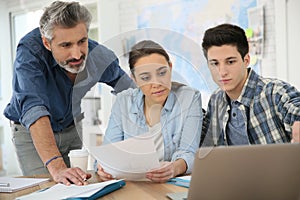 Teacher helping students working on project