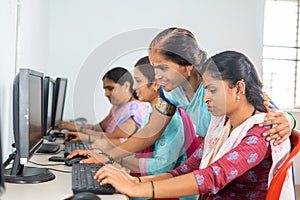 Teacher helping or teaching students during computer class training - concept of learning, personal support and