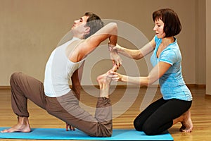 Teacher helping with yoga pose