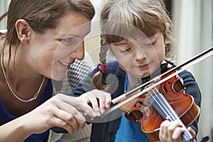 Teacher Helping Young Female Pupil In Violin Lesson