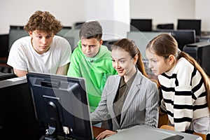 Teacher helping young student in computer class