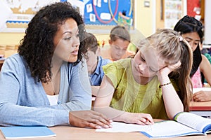 Teacher Helps Female Elementary School Pupil With Problem