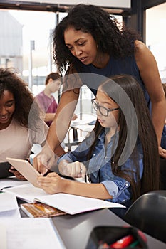 Teacher helps high school student with technology, vertical