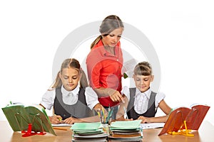 The teacher helps schoolgirls in the lesson, prompting how to solve the problem