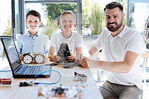 Teacher and his students posing during robotics workshop