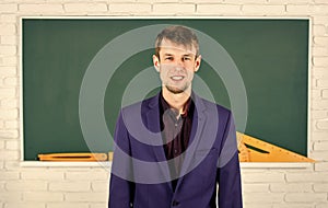 Teacher introduced to class young man at chalkboard, school year concept