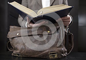 Teacher in a jacket open a book