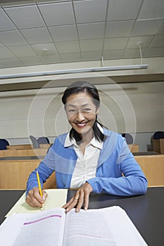 Teacher Jotting Down Notes In Classroom photo