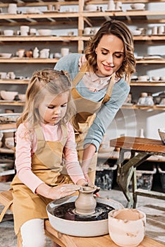 teacher and kid making ceramic pot