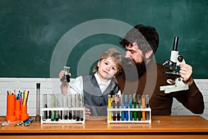 Teacher and kid. Teacher helping his teen students with chemistry or biology on education class. Teacher helping pupils