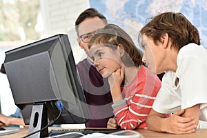 Teacher with kids in front of computer