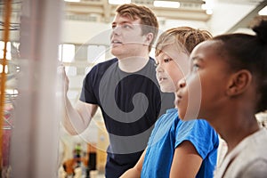 Teacher and kids looking at a science exhibit, close up photo
