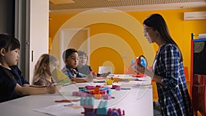 Teacher and kids making origami ship in art class