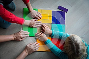 Teacher and kids play with puzzle, doing tangram