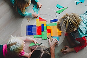 Teacher and kids play with puzzle, doing tangram