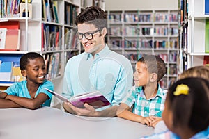 Teacher and kids reading book in library