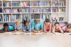 Teacher and kids reading book in library