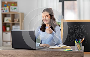 teacher with laptop having online class at home