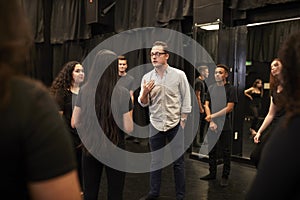 Teacher With Male And Female Drama Students At Performing Arts School In Studio Improvisation Class