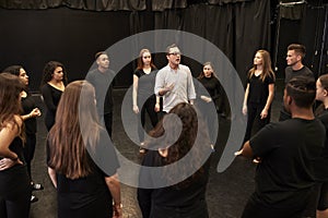 Teacher With Male And Female Drama Students At Performing Arts School In Studio Improvisation Class