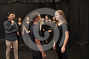 Teacher With Male And Female Drama Students At Performing Arts School In Studio Improvisation Class photo