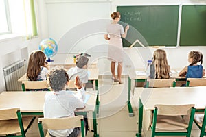 Teacher with marker standing at white board at lecture