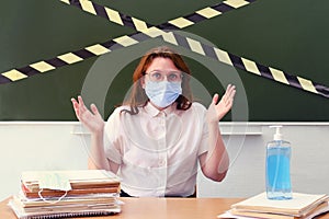 A teacher in a medical mask throws up his hands in dismay. Concept of problems with learning during coronavirus quarantine. photo