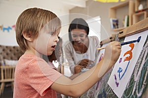 Teacher At Montessori School Helping Children in Art Class