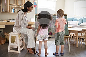 Teacher At Montessori School Helping Children in Art Class