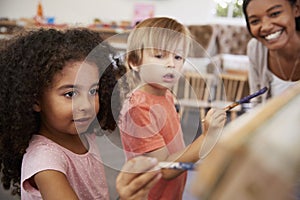 Teacher At Montessori School Helping Children in Art Class