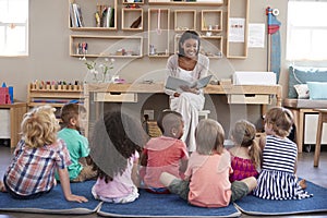 Teacher At Montessori School Reading To Children At Story Time photo