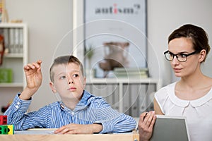 Teacher with notebook observes boy