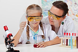 Teacher overseeing chemical experiment in science class photo