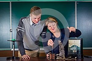 The teacher of physics explains to the pupil interaction of a magnetic field and electric field