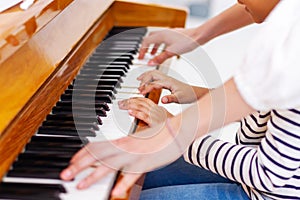 Teacher pianist gives piano classes to a young little student