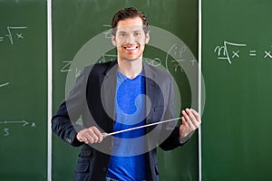 Teacher with pointer in front of a school class