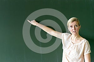 Teacher pointing at copy space place on chalkboard