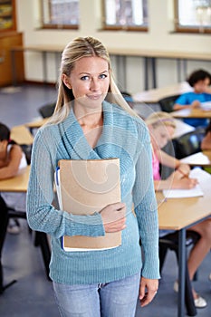 Teacher, portrait and woman with binder in class, elementary school or classroom. Education, teaching and female