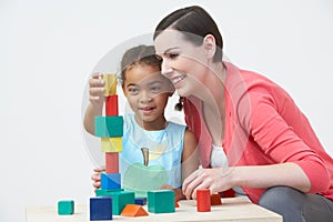 Teacher And Pre-School Pupil Playing With Wooden Blocks photo