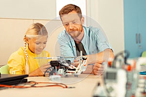 Teacher and pupil building a helicopter together.