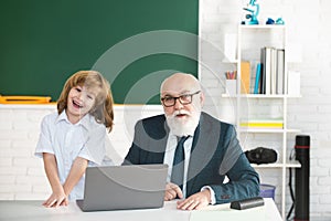 Teacher and pupil in classroom. Education concept. School learning concept. Boy elementary school. Old and Young