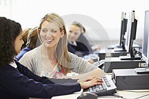 Teacher And Pupil In School Computer Class