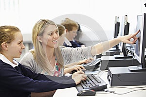 Teacher And Pupil In School Computer Class