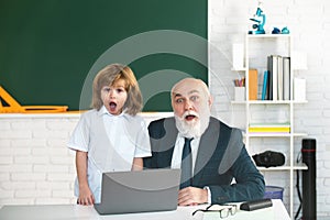 Teacher and pupil in school. Schoolboy in classroom with laptop. Online education.